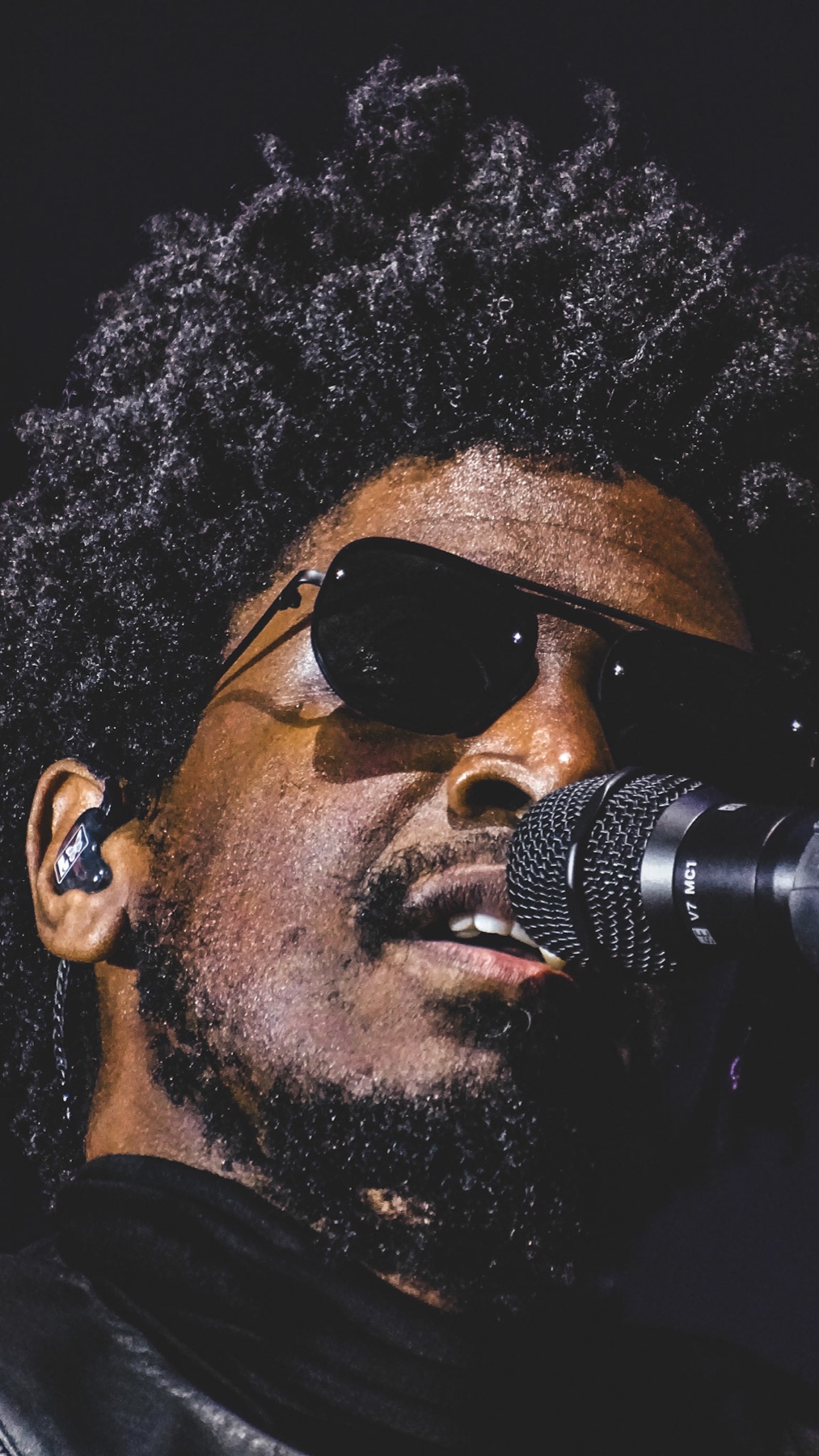 Labrinth performing in silhouette against a lit stage screen
