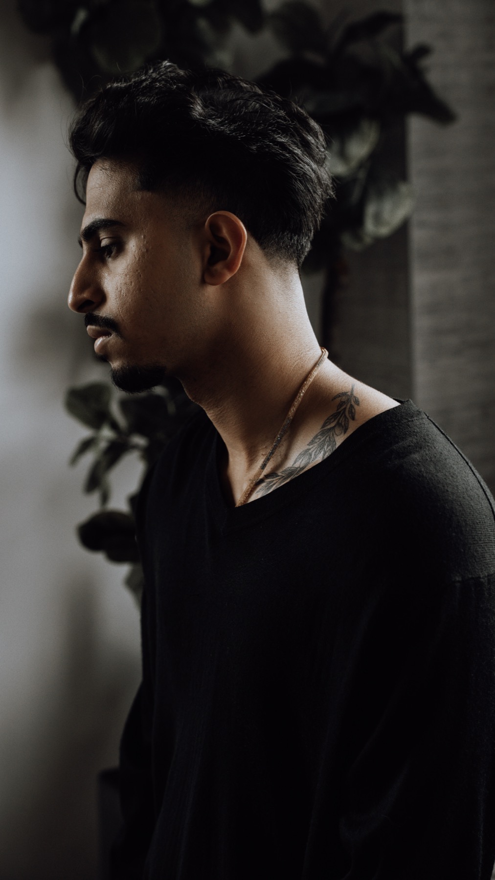 Low key portrait of a man in profile against a dark wall