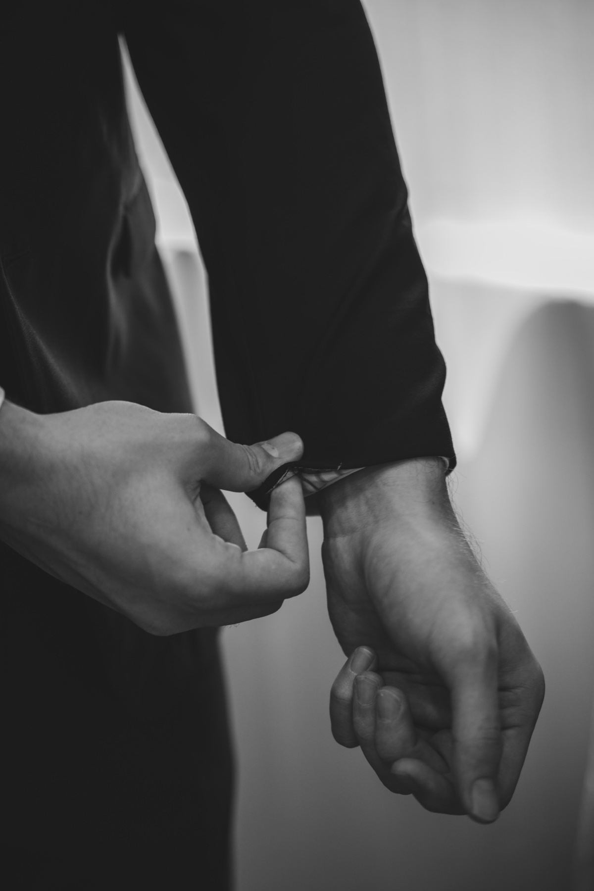 Fastening a cufflink before the ceremony, black and white
