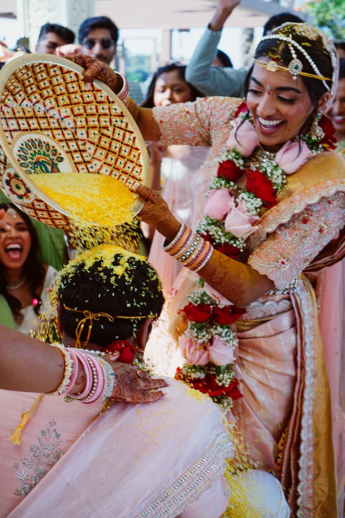 Turmeric poured over the bride as the family crowds in